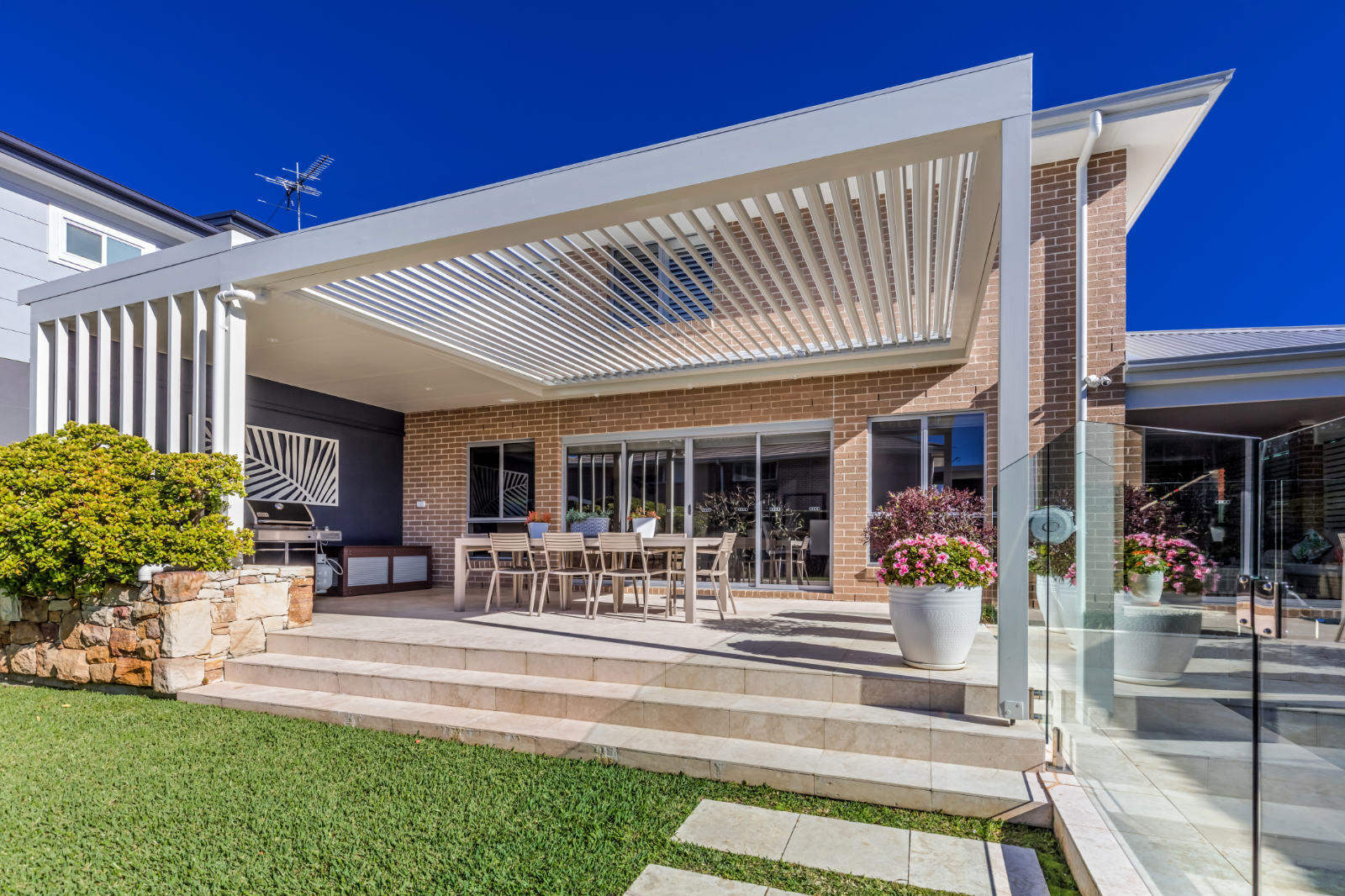 Gymea pergola with opening roof louvres attached to a brick home