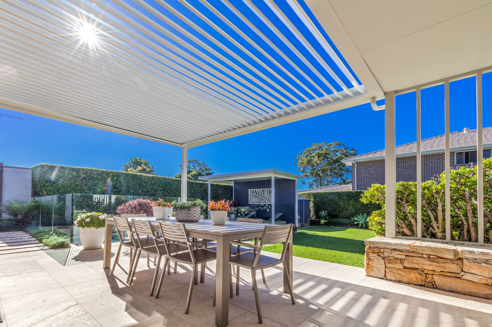 Gymea Bay pergola on a sunny day, showing how the opening and closing roof louvres control the sun and shade.