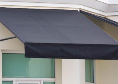 Small cheap fabric awning attached to brick.