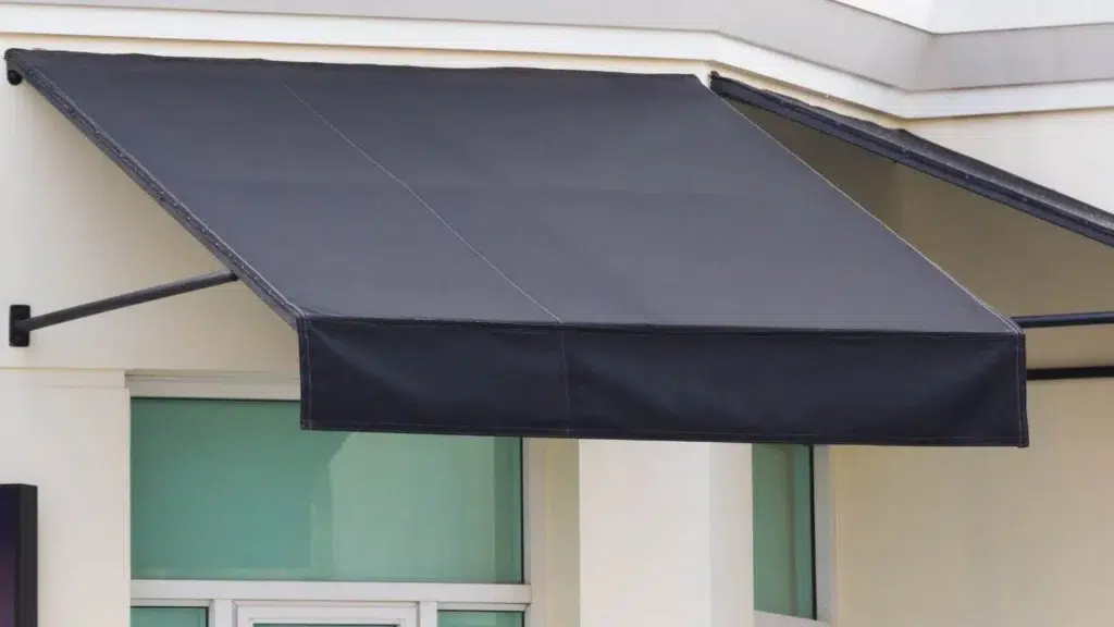 Small, cheap fabric awning attached to brick.