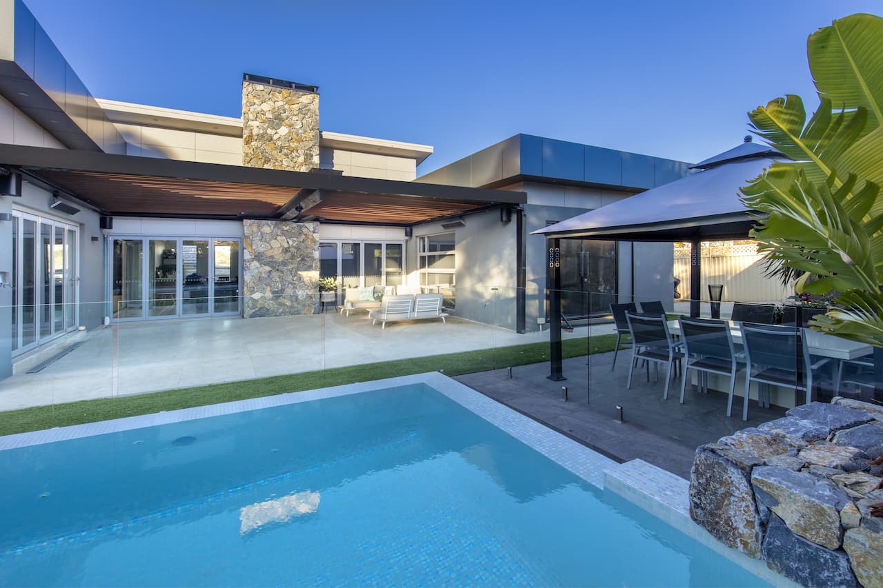 Dural pool and enteraining area in backyard with alfresco roofed area.
