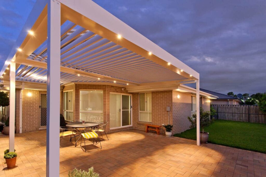 The Ponds pergola with opening roof and LED down lights under the cloudy night sky.