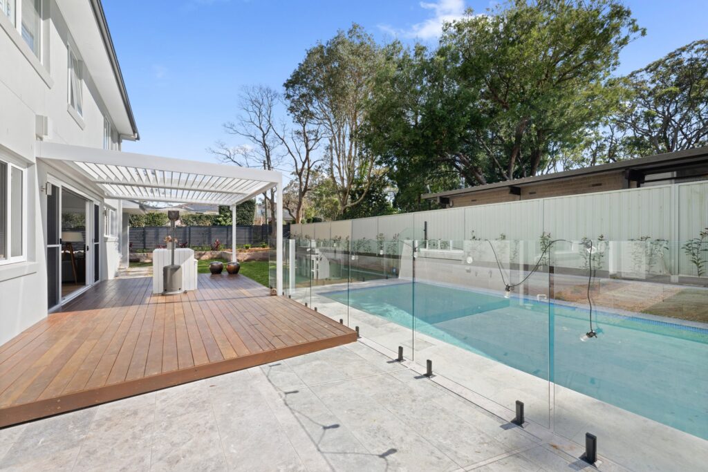 Pearl White louvre roof over St Ives poolside decking with pool fence.