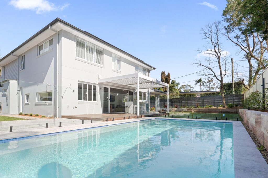 Pearl White louvre roof over St Ives poolside decking attached to house.